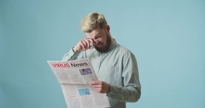 Sick Young Man Reading The Latest News About New Virus On Color Background