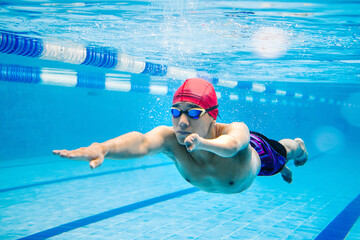 Paralympic Swimmer young latin man Underwater Training In Pool with hand hypoplasia in disability...