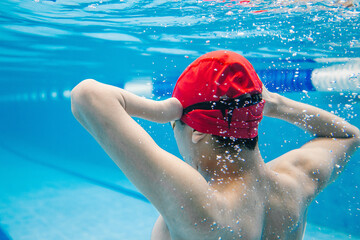 portrait of paralympic Swimmer young hispanic man Underwater Training In Pool with hand hypoplasia in disability concept