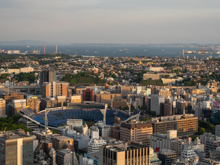 横浜の風景。建物に囲まれた横浜スタジアムと海。