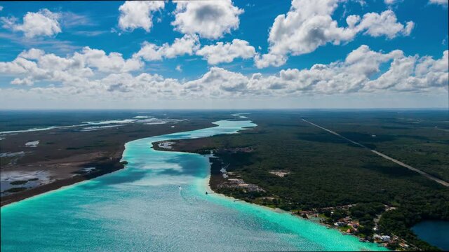 Aerial drone timelapse of Bacalar lagoon in Quintana Roo, caribbean part of M&eacute;xico. Mayan region on a dense jungle. Cloudy day with beautiful turquoise colors in the water.