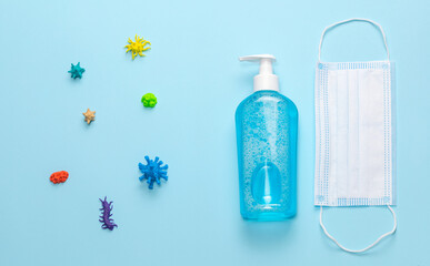Various viruses and microbes on a blue background along with a medical mask and sanitizer. Top view
