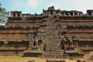 Angkor. An ancient temple in the form of a stepped pyramid with a staircase. At the top there is a...