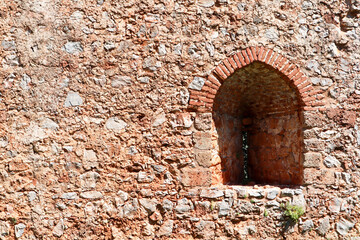 Fototapeta na wymiar old fortress red brick stone wall with the arch window close up