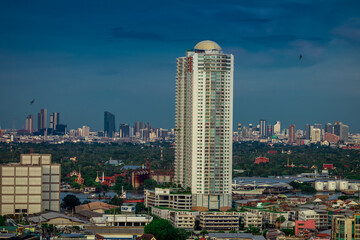 Naklejka premium The high angle background of the city view with the secret light of the evening, blurring of night lights, showing the distribution of condominiums, dense homes in the capital community