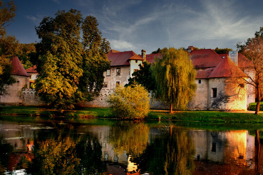 Castle Otočec on the river Krka in southern Slovenia, evening  sunset scene with reflection of castle on the water