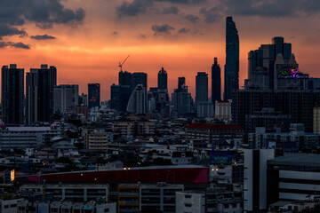Obraz premium The high angle background of the city view with the secret light of the evening, blurring of night lights, showing the distribution of condominiums, dense homes in the capital community