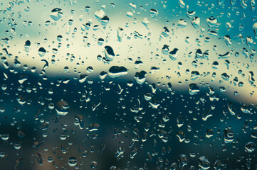 Rain drops on window glasses surface with sunset. drops on glass spray on window background for dark text view selective focus
