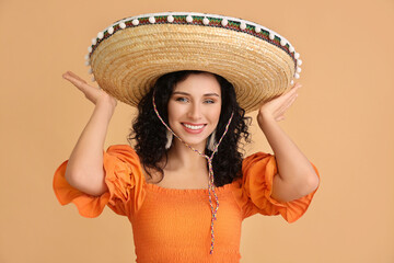 Beautiful woman in sombrero hat on color background