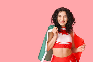 Beautiful cheerleader with Mexican flag on color background