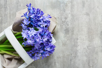 Basket with beautiful hyacinth flowers on light background