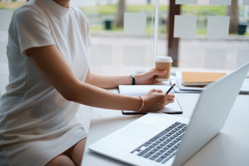 Business woman concentrates on a webinar on her laptop computer.