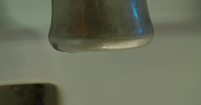 Closeup of a faucet as water drips out.