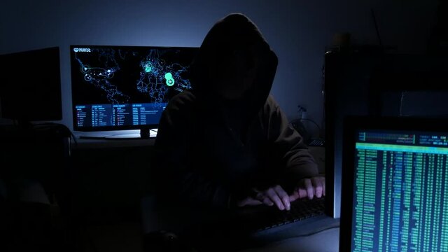 Computer hacker types code attempting to hack a computer server