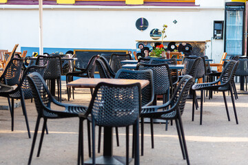 empty tables and chairs at a outdoor restaurant in sunny day