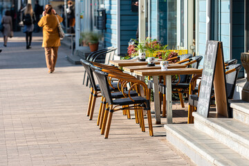 sidewalk open air cafe with empty chairs and  tables