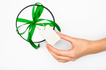 girl reads a note with a gift. white gift box on a light background close-up. mockup