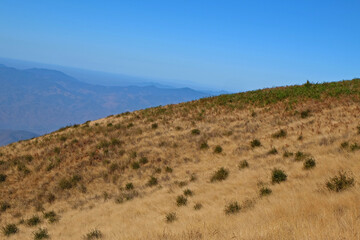 Natural landscape of green mountain range with misty summit hill