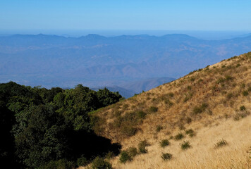 Natural landscape of green mountain range with misty summit hill