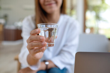 Closeup image of a woman holding a glass of water to drink