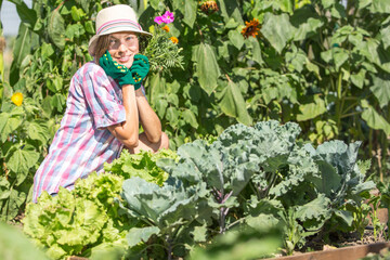 person working in garden. Young woman in summer field garden planting watering care about rows, plants