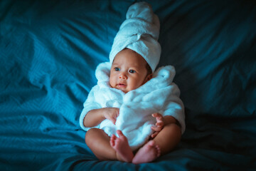 baby girl in shower suit a posing relax on the sofa blue color