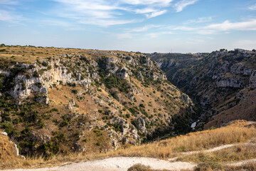 View of Gravina river canyon and park of the Rupestrian Churches of Matera with houses in caves di Murgia Timone near ancient town Matera (Sassi), , Basilicata,  Italy