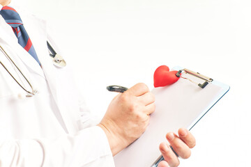 Close-up of a doctor filling out a medical form on a clipboard while standing in a hospital