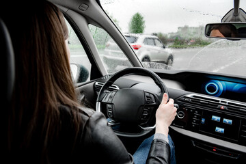 Female driving a car in rainy weather.