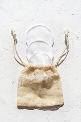 Cosmetic washable cotton sponges set in bag on white background. Natural reusable zero waste makeup remove pad © Julia Klintsova