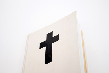 White book with a cross on the cover. Holy Bible