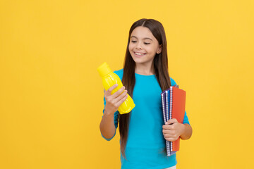 going to drink. cheerful kid with juice or water and books. smiling teenager student.