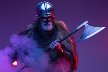 Furious old viking warrior with axe in smoke