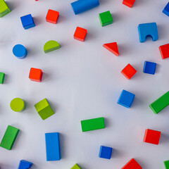 Colorful wooden blocks on light  background. Creativity toys. Geometric shapes - cube, triangular prism, cylinder. The concept of logical thinking with copy space.