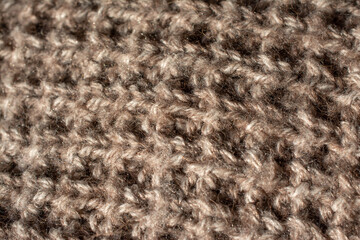 Close up of a part of a large knitted jumper with an English knit. Natural colour.