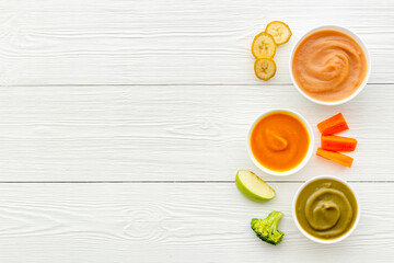Set of bowls with baby food with fruits and vegetables. Kid feeding, top view