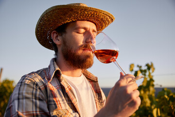 Male farmer drinking wine on vineyard