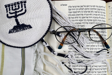 Open Torah, kippah, tallit  and pair of glasses.