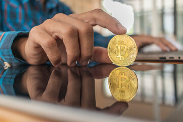 An investor holds cryptocurrencies Bitcoin in hand because he believes in investing in virtual...