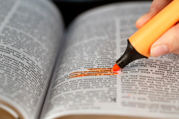 Fototapeta premium Woman studying the bible. Close up on hand and highlighter. France.