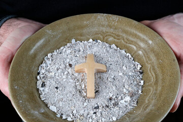 Close-up on hands and ashes.  Ash Wednesday celebration. Lent season. France. - obrazy, fototapety, plakaty