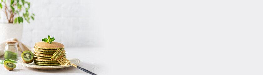 Green matcha pancakes with matcha tea or spinach banner. Healthy breakfast with superfoods. Light...