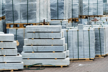 Concrete curbs for road construction. A lot of building material prepared for loading lies in the warehouse of the factory. Close-up