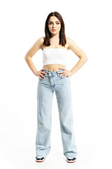 Obraz premium Cute and confident young stylish woman in jeans and summer top with akimbo pose. Full body length isolated on white background