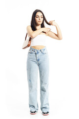 Fototapeta premium Candid young trendy woman adjusting top shoulder strap in summer clothes. Full body length isolated on white background