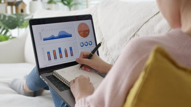 Young asian woman employee busy work online on laptop computer screen at home freelance sale data analytic, data driven marketing science scientist engineer for business intelligence reskill upskill.