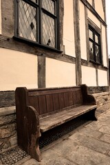 old church pew bench outside timber frame building
