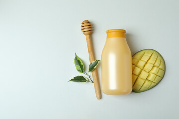 Shower gel, mango and dipper on white background