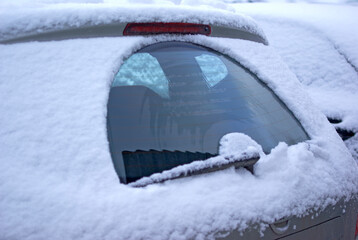 Frozen car. Snow and ice on the car. Rear window with windscreen wiper - obrazy, fototapety, plakaty