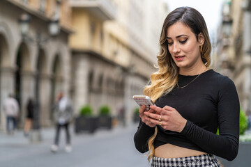 Fototapeta premium young woman looking at smartphone in hand